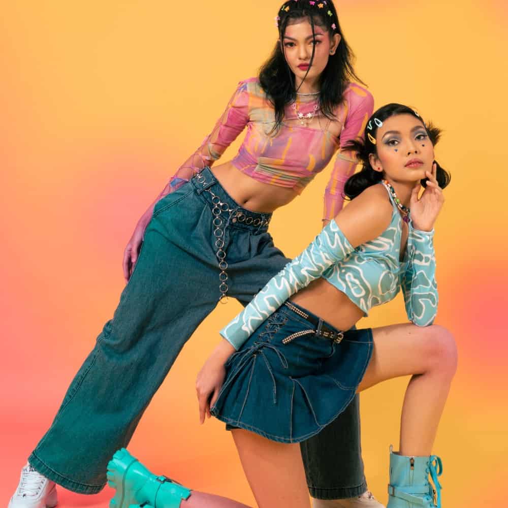 2 women wearing 90's clothing posing in front of the camera